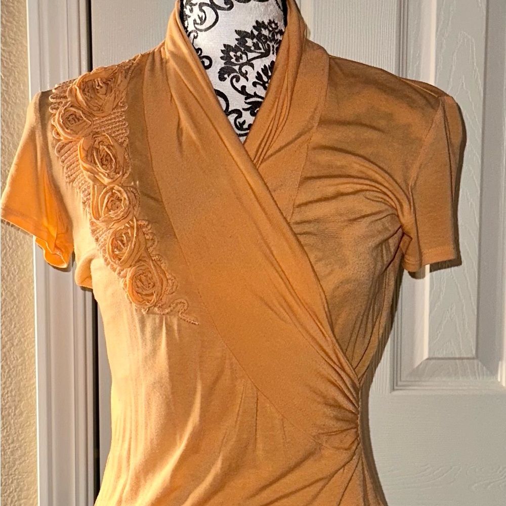 Orange wrap top with floral details. Super soft material. Size small. Saks Fifth